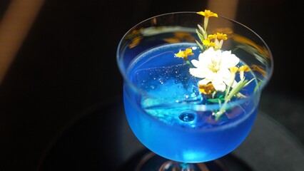 Closeup beautiful mixed vodka blue hawaii cocktail decorated with flower at luxurious counter bar perfect for advertisement in vibrant color presentation highlight atmosphere at nightclub. Vinosity.