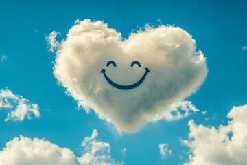 heart-shaped cloud with a smiling face floats in a clear blue sky, creating a cheerful and whimsical scene