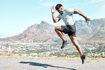 Indian man, athlete and running for fitness on road for exercise, training and workout for race. Jump, motion and agile runner in outdoor practice for wellness, speed progress and health by mountain
