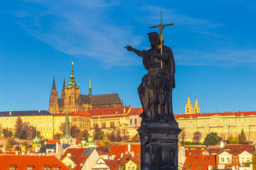 Cityscape - view of the sculpture of St. John the Baptist on Charles Bridge with Prague Castle in...
