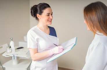 smiling Female Patient And Doctor Have Consultation In medical clinic