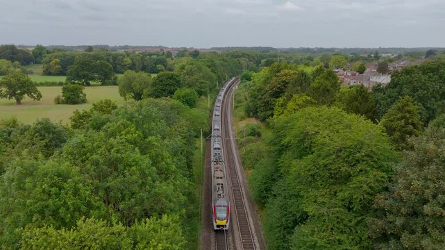 Stansted express service train passing through a rural area in England