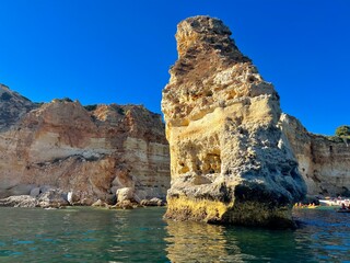 Oddly shaped jagged rock formations and cliffs at Lagoa Beach, Faro District, Southern Portugal.