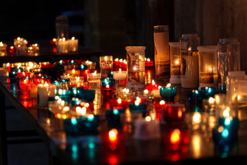 A table full of colorful candles inside a church