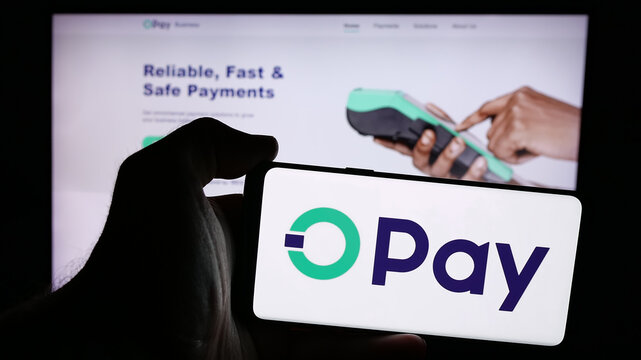 Stuttgart, Germany - 08-26-2024: Person holding mobile phone with logo of Nigerian fintech company Opay Digital Services Limited in front of web page. Focus on phone display.