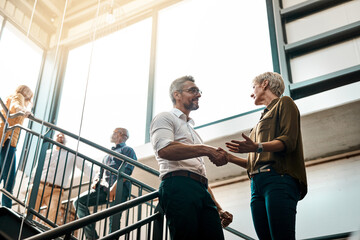 Employees, handshake and office with greeting on stairs for business deal and opportunity. People, thank you and welcome with partnership, support and agreement for teamwork, collaboration and smile © SometimesNever/peopleimages.com