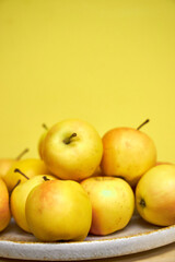 Modern minimalist still life with yellow apples on yellow background