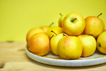 Modern minimalist still life with yellow apples on yellow background