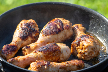 chicken legs are fried on a pan