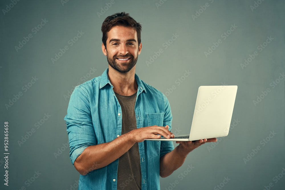 Poster Laptop, startup and portrait of man in studio with research for creative software with project development. Happy, tech and graphic designer working on multimedia art on computer by gray background.