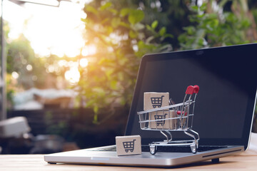 Shopping online. cardboard box with a shopping cart logo in a trolley on laptop keyboard. Shopping...