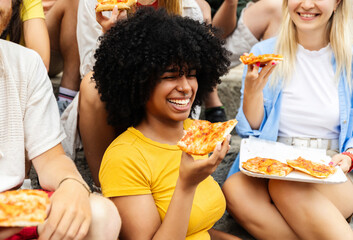 Happy group of young multiracial friends eating take away pizza in Italy during summer vacation....