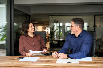 Happy professional executives team discussing papers working together in office. Female attorney...