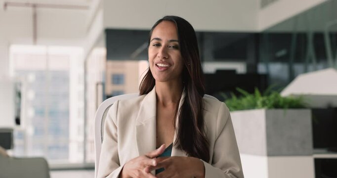 Beautiful businesswoman hold virtual meeting with partners or shareholders, make speech, provide information, explanation, share contract details with colleagues via videocall application at workplace