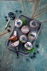 Traditional American oatmeal muffin with blueberries and walnuts served as top view a baking tray