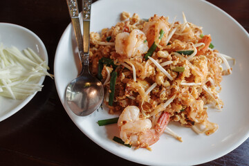 A close-up shot of a delicious and authentic Shrimp Pad Thai served on a white plate.