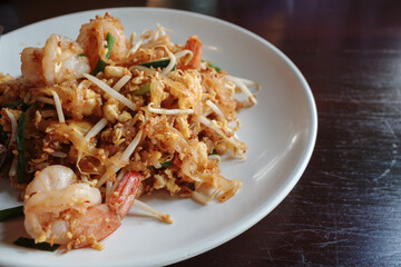 A close-up shot of a delicious and authentic Shrimp Pad Thai served on a white plate.