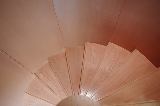  A detailed top-down view of a wooden spiral staircase showcasing smooth, natural wood grain and elegant design.