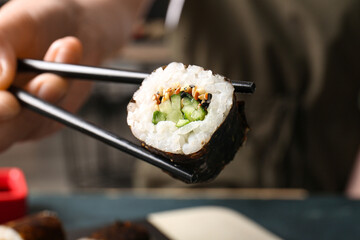 Woman eating tasty maki roll, closeup view © Pixel-Shot