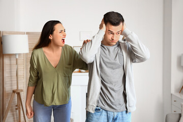 Angry young woman quarreling with her husband at home