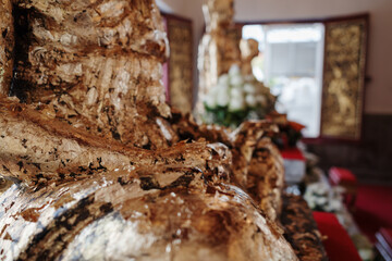 Close-up of a gold leaf-covered Buddha statue inside a Thai temple. 
