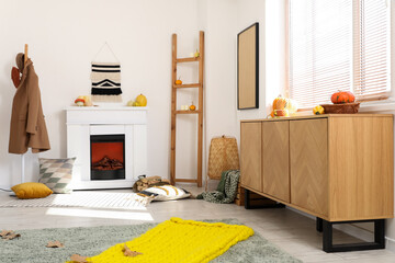 Interior of living room with fireplace, pumpkins and commode