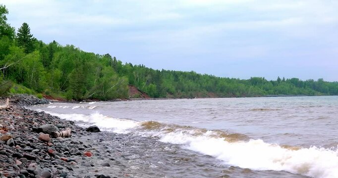Footage of waves and splashes on the rocks at the North Shore of Lake Superior in Minnesota, on a cloudy day.