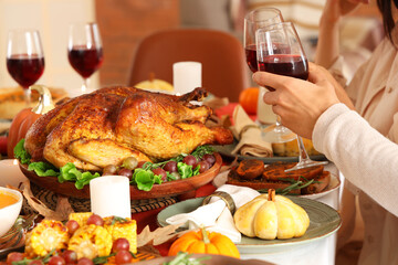 Couple of friends having dinner at festive table on Thanksgiving Day, closeup