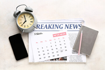 Newspaper with calendar, alarm clock and mobile phone on white table. Black Friday sale
