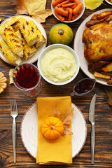 Table setting with pumpkin and tasty food for Thanksgiving Day on wooden background