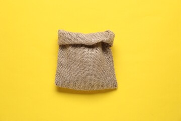 One burlap sack on yellow background, top view