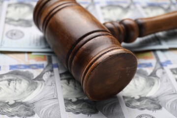 Alimony. Judge's gavel on dollar banknotes, closeup