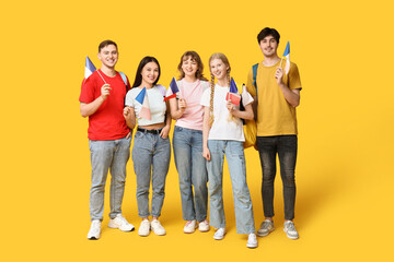 Naklejka premium Group of students with French flags on yellow background