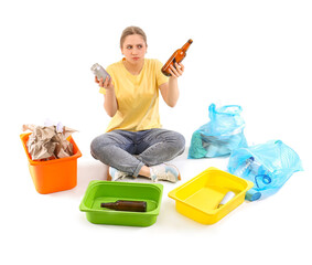 Thoughtful young woman sorting trash on white background