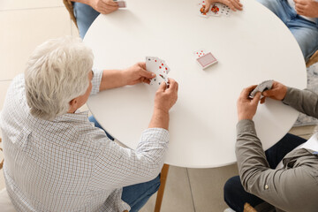 Old men playing cards at home