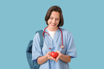 Female medical intern with heart on blue background