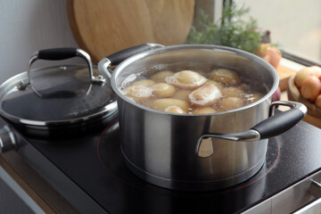 Boiling potatoes in pot on stove in kitchen