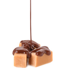 Pouring tasty melted chocolate onto caramel candies on white background