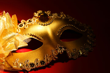 Naklejka premium Beautiful golden carnival mask on red background, closeup
