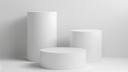 A minimalist display featuring three white cylindrical podiums on a light background.