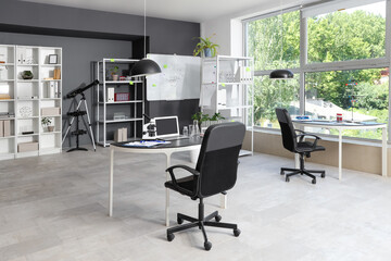 Interior of laboratory with desks, shelf units and whiteboard