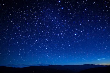 Naklejka premium A stunning natural spectacle, often seen in remote areas with minimal light pollution, where countless stars create a breathtaking celestial display against the deep blue night sky, ai
