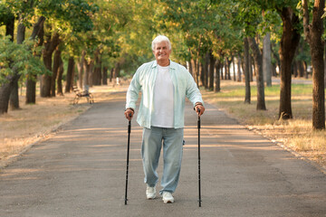 Mature man training with walking poles in park