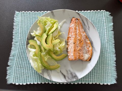 Plato blanco con lechuga y filete de salm&oacute;n frito 