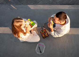 Young couple having lunch outdoors, top view