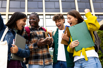 Cheerful students college friends receiving good news celebrating looking at phone together.