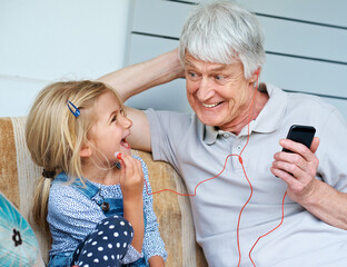 Senior man, child and smartphone or music on couch for audio, media and together in living room....