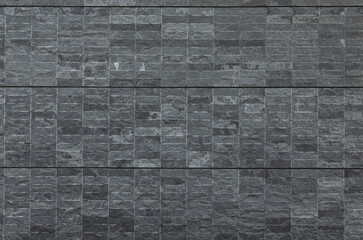 Wall covered with black natural stone tiles
