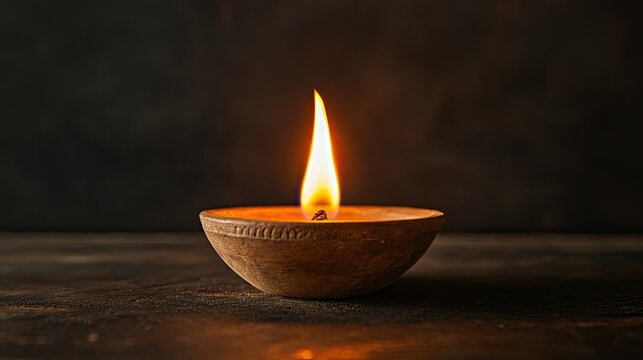 Traditional Jain deepak with a soft flame, no people, dark background, ample copy space