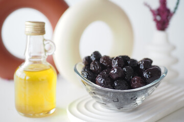 A beautifully arranged table setting featuring olives and a bottle of exquisite olive oil